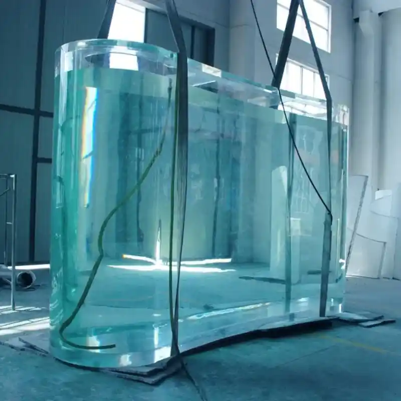 Craftsman constructing a large, custom-built acrylic aquarium in a workshop.